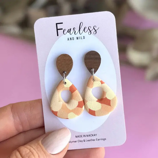 Mid-size statement earrings with a rounded shape and vibrant yellow-orange confetti blend, handmade from polymer clay with stainless steel posts—lightweight and ideal for sensitive ears.