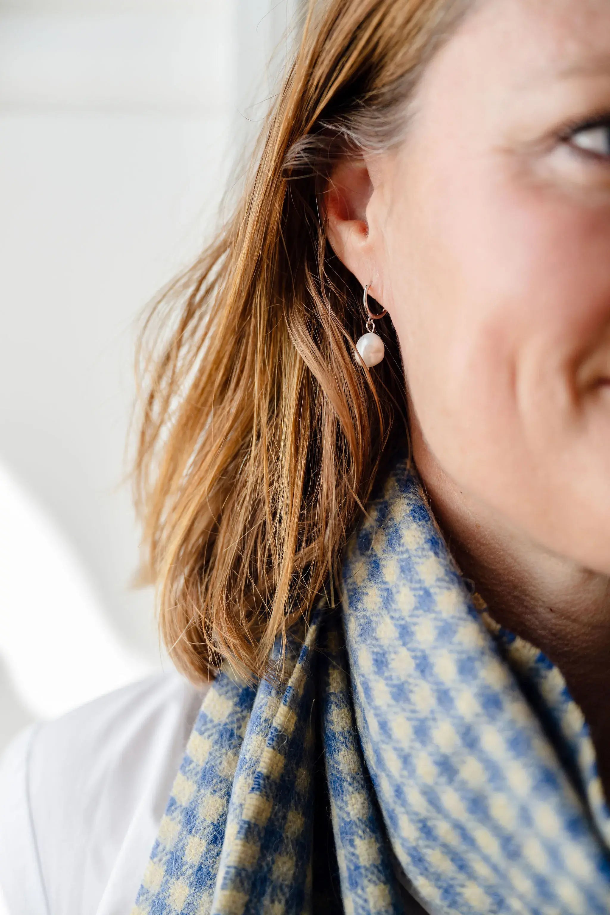 Close-up of a person wearing pearl earrings 
