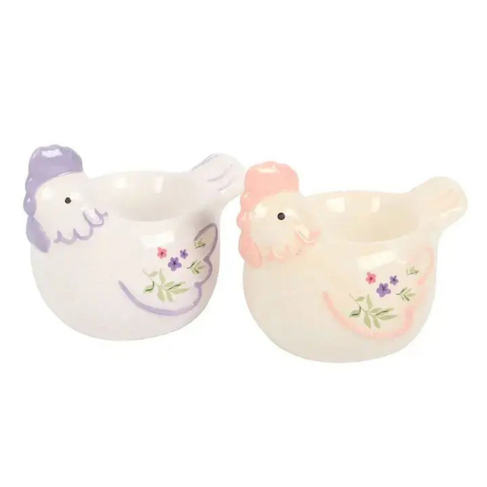Two ceramic chickens with floral designs on a white background