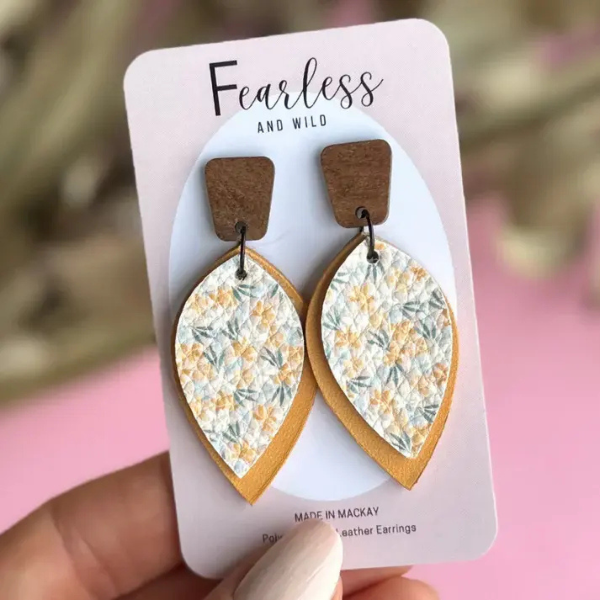 Elongated leather drop earrings with a floral front and soft mustard back, featuring stainless steel posts—lightweight, feminine, and ideal for sensitive ears.