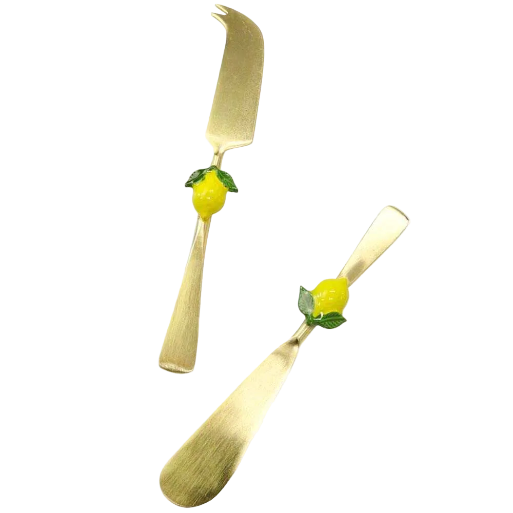 Gold spreader and cheese knife set with lemon decorations on a white background