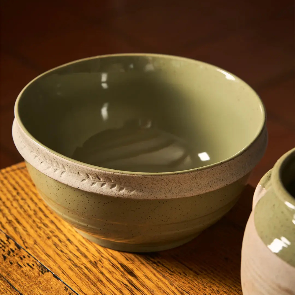 Green ceramic bowl on a wooden surface with a blurred background