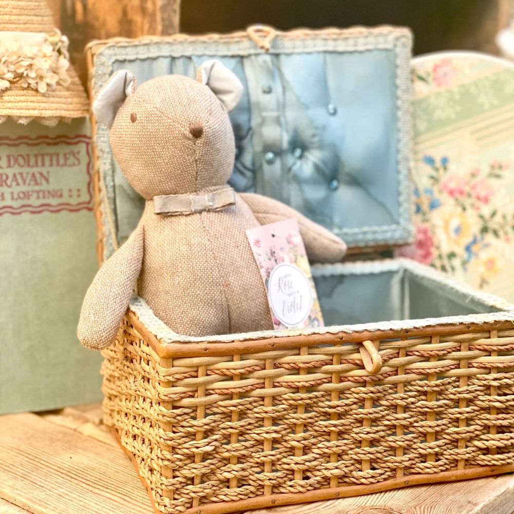 Stuffed animal toy in a wicker basket with a blurred background