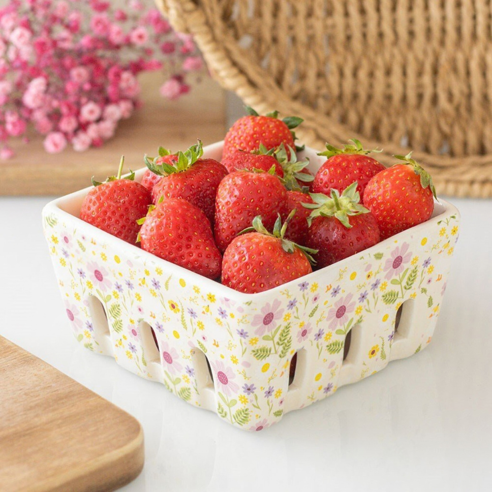 Basket of strawberries with a floral pattern berry basket on a white surface
