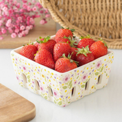 Basket of strawberries with a floral pattern berry basket on a white surface